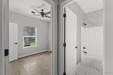 Full bath featuring ceiling fan, baseboards, and w