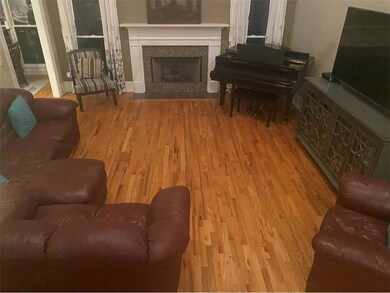 Living area with wood finished floors and a tile fireplace