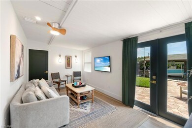 Living room with french doors, wood ceiling, beamed ceiling, ceiling fan, and hardwood / wood-style floors