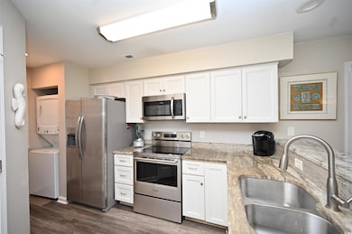 Kitchen featuring stacked washer and dryer, stainl