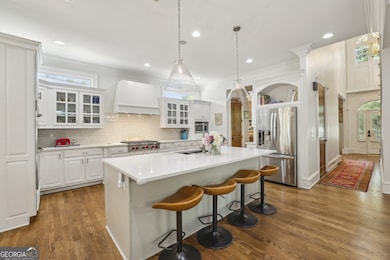 The Chef's Kitchen is a true showpiece outfitted with a Wolf Range and Custom Hood, Quartzite Countertops, Double Oven, Butler's Pantry, Wine Cooler, and a Statement Island for gathering.