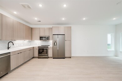 Kitchen featuring stainless steel appliances, lig