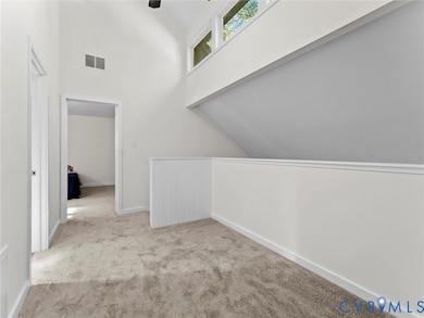 Bonus room featuring light colored carpet and a high ceiling