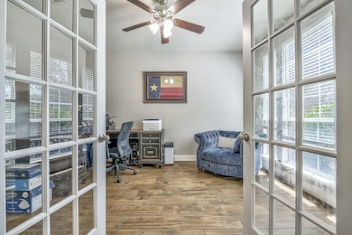Home office with wood finished floors, plenty of natural light, and ceiling fan
