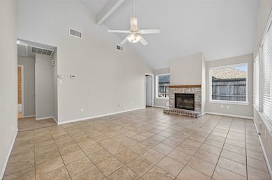 The spacious living area features vaulted ceilings, large windows that fill the room with natural light, and a cozy brick fireplace that serves as the perfect focal point.