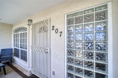 View of exterior entry with stucco siding and a po