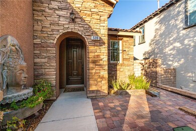 View of exterior entry with stone siding and a pat
