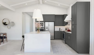 Kitchen with waterfall island and vaulted ceiling
