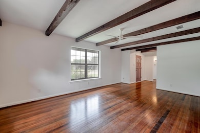 Spare room featuring beam ceiling, wood finished 