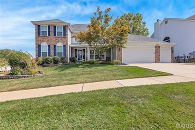 Summer exterior: View of front of home with a front yard, driveway, an attached garage and brick siding