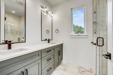 Full bath with marble look tiles, baseboards, dou