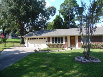 Ranch-style home featuring a front yard and a gara