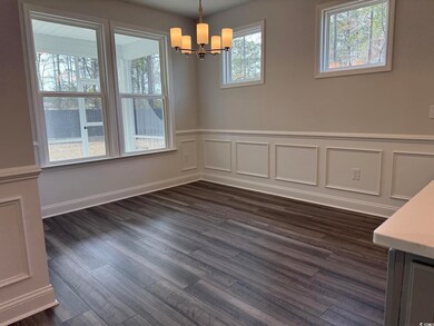 Unfurnished dining area featuring dark wood-type flooring and a chandelier