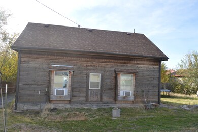Back of house featuring a trampoline, a shingled roof, and cooling unit