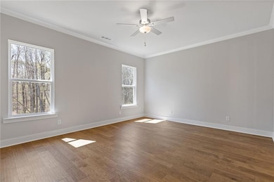Unfurnished room featuring dark wood-type flooring, crown molding, and ceiling fan