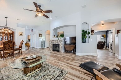 Living room with arched walkways, a ceiling fan, a