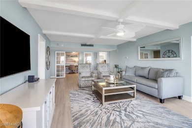 Living area with light wood-style flooring, beam ceiling, a ceiling fan, and coffered ceiling