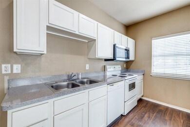 Kitchen with white cabinets, white appliances, and