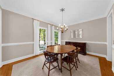 Dining area featuring crown molding, light wood-style flooring, and a chandelier