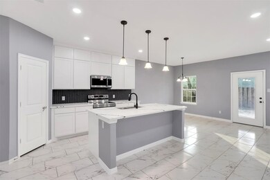 Kitchen featuring backsplash, white cabinetry, sta