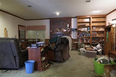Living room with brick wall and a textured ceiling