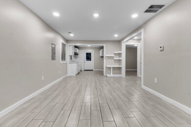 Unfurnished living room featuring wood tiled floors, recessed lighting, and electric panel