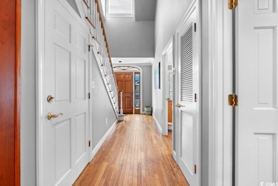 Corridor with a high ceiling and light hardwood / 
