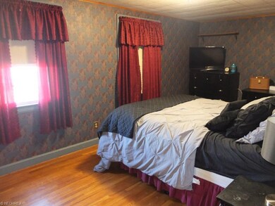 Master bedroom with hardwood flooring and walk-in 