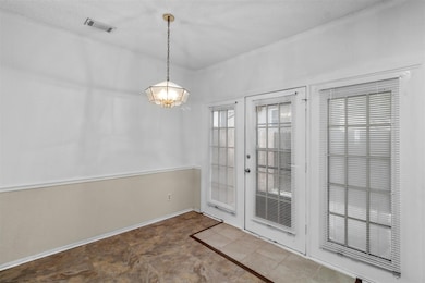 Entryway with an inviting chandelier, a textured c