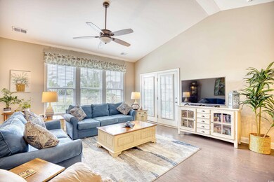 Living room featuring lofted ceiling, ceiling fan,