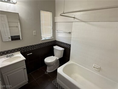Full bathroom with vanity, toilet, tile patterned