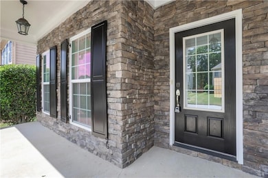 Doorway to property with covered porch and stone siding