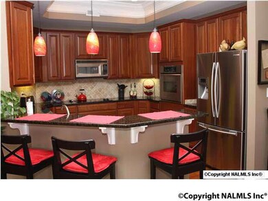 Kitchen with Granite Counter Tops, Wood Floors and Kitchen Aid Appliances.