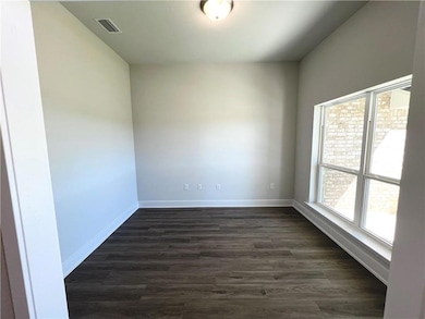 Spare room featuring dark wood-style floors