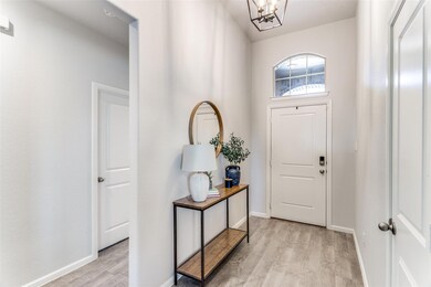 Foyer with baseboards, light wood-style floors, an