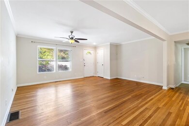 Unfurnished living room featuring crown molding, v