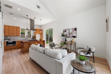 Living area with light wood-type flooring, vaulte