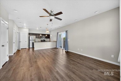 Unfurnished living room featuring dark wood finished floors, a textured ceiling, and ceiling fan