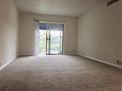 Living area from entry hall with sliding glass doors opening onto balcony