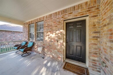 Entrance to property with covered porch and brick