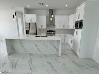 Kitchen featuring a center island with sink, sink,
