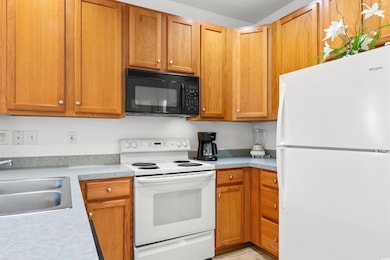 Kitchen featuring sink and white appliances