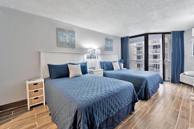 Bedroom featuring a wall of windows, a textured ce