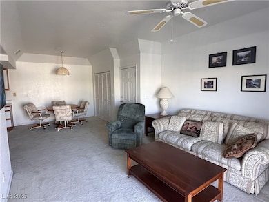 Living area featuring ceiling fan, visible vents,