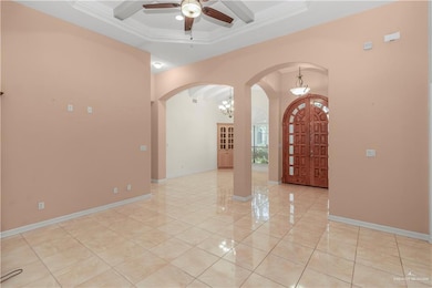 Entryway with arched walkways, ceiling fan, crown molding, beamed ceiling, and a chandelier