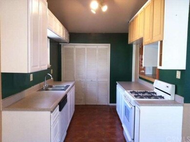 White cabinets and granite like formica line the k