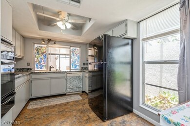 Kitchen with black appliances, ceiling fan, a rais