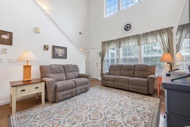 Living area with wood finished floors, a high ceil