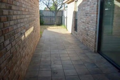 View of property exterior with brick siding and a patio area