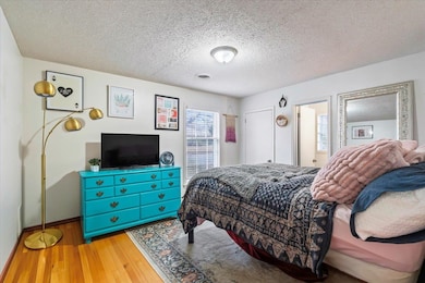 Bedroom featuring hardwood / wood-style floors and a textured ceiling
